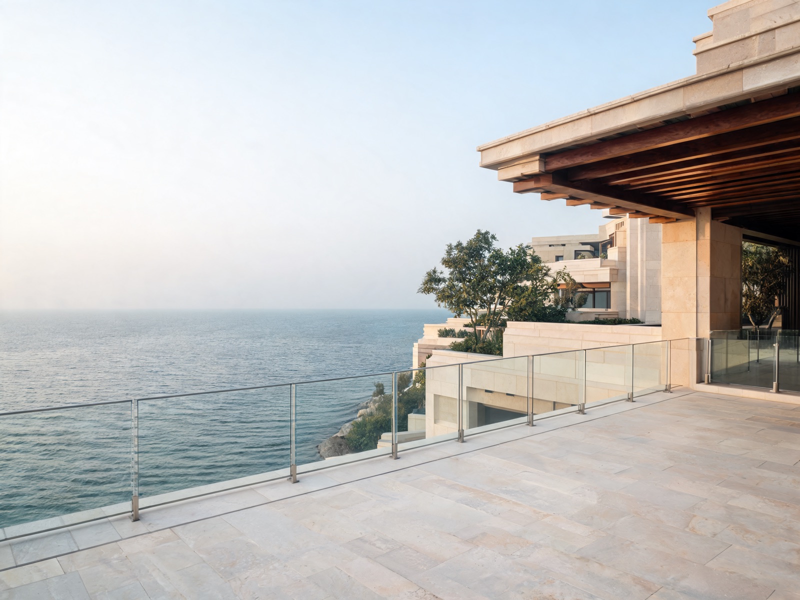 A sea-facing terrace with a glass balustrade and a timber loggia